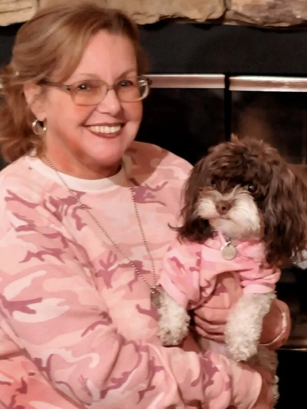 Pam Stewart with Cockapoo wearing matching pink shirts